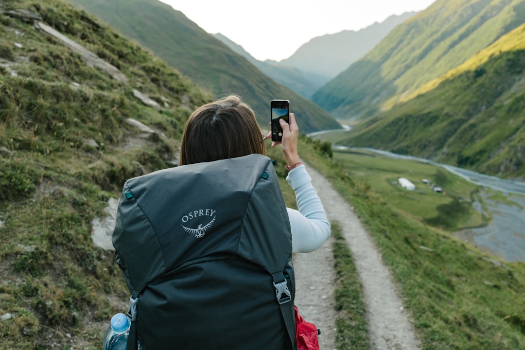A phone used during travel, representing offline AI planning. — Photo by Dmitrii Vaccinium on Unsplash. Source: https://unsplash.com/photos/woman-walking-near-dirt-road-between-mountain-range-during-daytime-pyM7TYWutJM